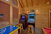 Arcade games and pool table in cabin game room